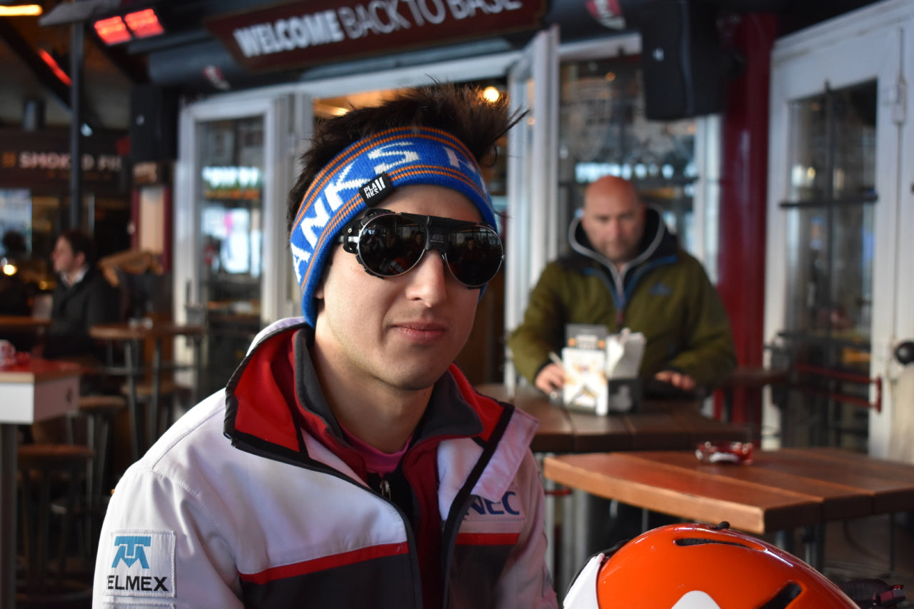 Skier wearing sustainable UV-protective sunglasses on snowy mountain slopes - winter eyewear essential