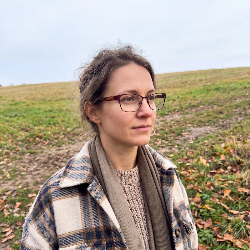 Women's eyeglasses with a burgundy front and titanium frame, featuring acetate sides and a magnetic sun-clip.